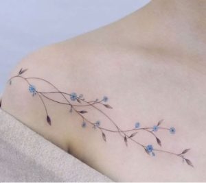 tatuaje en la clavicula con flores azules